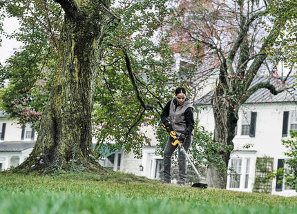 DEWALT DCST922P1 en uso, corte de césped alrededor de árbol