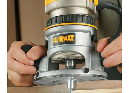 DEWALT DW616 dando forma al borde de una pieza de madera, vista de cerca