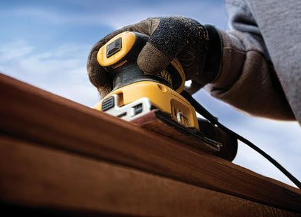 Lijadora DEWALT DWE6411-B3 en uso sobre madera